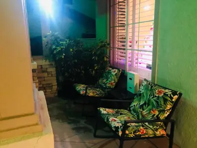 two chairs sitting next to a window with plants at Balloons and Wine in Murrieta