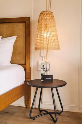 a table with a lamp next to a bed at The Green Room Hotel in Oceanside