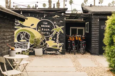 a mural on the side of a building with bikes parked outside at The Green Room Hotel in Oceanside