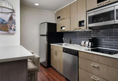 a kitchen with a sink and a refrigerator at Hyatt House San Diego Sorrento Mesa in Sorrento