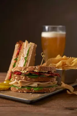 a sandwich on a plate next to a glass of beer at Hyatt House San Diego Sorrento Mesa in Sorrento