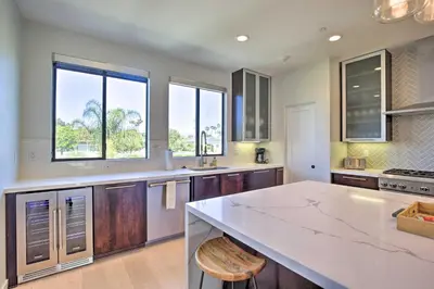 a kitchen with a large white counter and windows at Chic San Diego Abode Rooftop Balcony and Bay Views! in San Diego