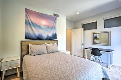 a bedroom with a bed with a desk and a painting on the wall at Chic San Diego Abode Rooftop Balcony and Bay Views! in San Diego