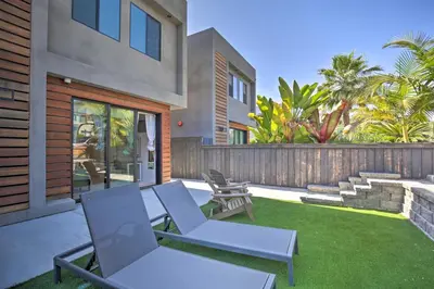 a backyard with two chairs and a fence and grass at Chic San Diego Abode Rooftop Balcony and Bay Views! in San Diego