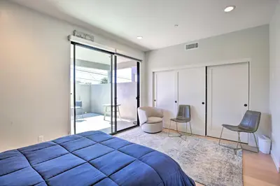 a bedroom with a large blue bed and chairs at Chic San Diego Abode Rooftop Balcony and Bay Views! in San Diego