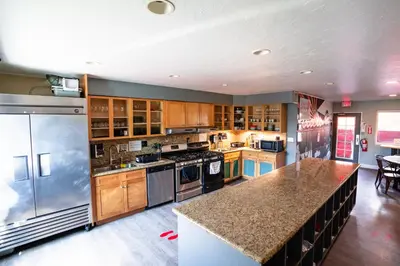 a large kitchen with stainless steel appliances and wooden cabinets at California Dreams Hostel - Ocean Beach in San Diego