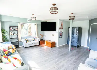 a living room with a couch and a flat screen tv at California Dreams Hostel - Ocean Beach in San Diego