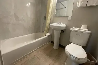 a bathroom with a toilet and a sink and a tub at Big 7 Motel Chula Vista I-5 in Chula Vista
