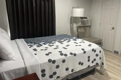 a bedroom with a bed with a black and white comforter at Big 7 Motel Chula Vista I-5 in Chula Vista