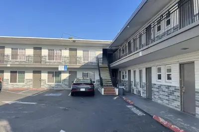 a car parked in a parking lot next to a building at Big 7 Motel Chula Vista I-5 in Chula Vista