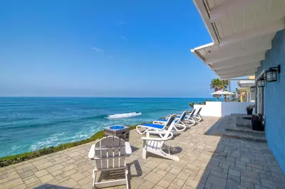a row of chairs sitting on a patio overlooking the ocean at Oceanfront Villa with Private Beach Access, Remodeled Kitchen in Carlsbad