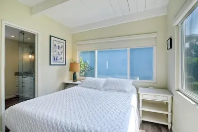 a bedroom with a white bed and a window at Oceanfront Villa with Private Beach Access, Remodeled Kitchen in Carlsbad