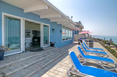 a row of blue chairs sitting on a patio at Oceanfront Villa with Private Beach Access, Remodeled Kitchen in Carlsbad