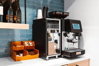 a coffee machine sitting on a counter next to a bottle of wine at Del Mar Beach Hotel in San Diego