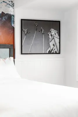 a picture frame hanging on a wall next to a bed at Del Mar Beach Hotel in San Diego