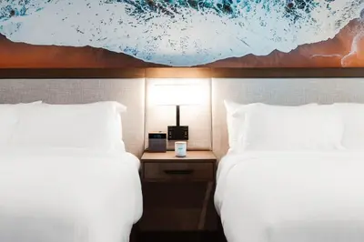 a hotel room with two beds and a table with a lamp at Del Mar Beach Hotel in San Diego