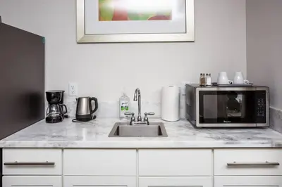 a kitchen counter with a microwave and a sink at Comfy Studio with Cali King Size Mattress in San Diego