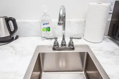 a kitchen sink with a faucet and a roll of paper towels at Comfy Studio with Cali King Size Mattress in San Diego