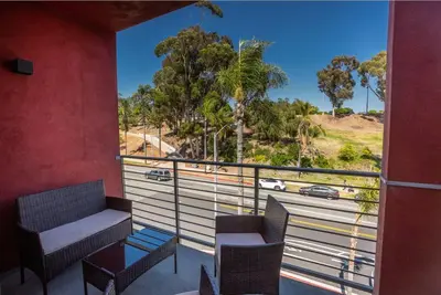a balcony with a couch and chairs and a view of a road at Cozy Studio next to San Diego DT and Balboa Park in San Diego