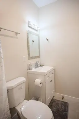 a white bathroom with a toilet and a sink at 1-Bedroom with Cali King Size Bed in San Diego in San Diego