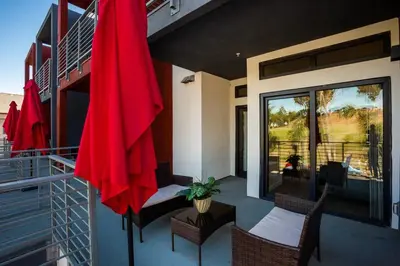 a patio with a red umbrella on a balcony at Awesome Balboa Park View with Huge Balcony in SD in San Diego