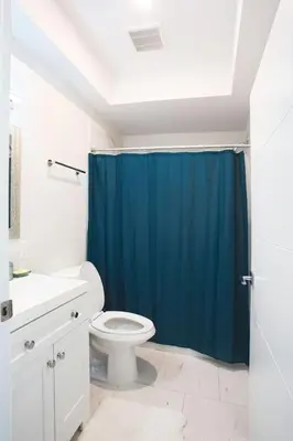 a bathroom with a blue shower curtain and a toilet at Lovely Studio w Full Kitchen in Heart of San Diego in San Diego