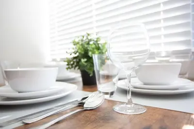 a table with plates and a wine glass on it at Luxurious Design One Bedroom Apt near Balboa Park in San Diego