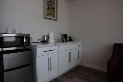 a kitchen with white cabinets and a black microwave at Luxurious Design One Bedroom Apt near Balboa Park in San Diego
