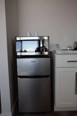 a microwave sitting on top of a refrigerator in a kitchen at Luxurious Design One Bedroom Apt near Balboa Park in San Diego
