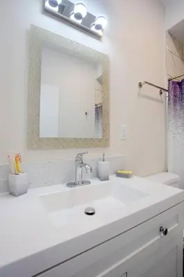 a white bathroom with a sink and a mirror at Luxurious Design One Bedroom Apt near Balboa Park in San Diego