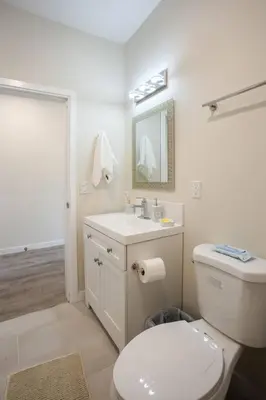 a white bathroom with a toilet and a sink at Cute Studio With Large Balcony and Great Park View in San Diego