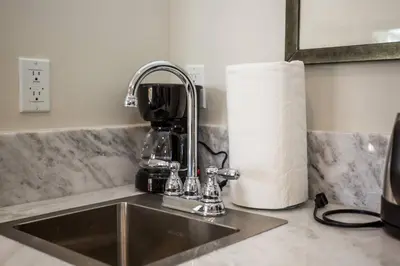 a kitchen sink with a coffee mixer and a roll of paper towels at Cute Studio With Large Balcony and Great Park View in San Diego