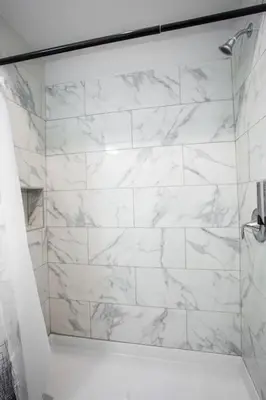 a bathroom with a shower with white marble walls at Luxurious Studio in Heart of San Diego w Cali King in San Diego