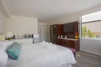 a bedroom with a large white bed and a kitchen at Downtown View 4 Sleepers Studio- Great for Getaway in San Diego