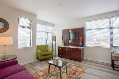 a living room with a purple couch and a tv at One Bedroom Apartment with Luxurious Furnitures in San Diego