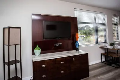 a living room with a entertainment center with a tv at One Bedroom Apartment with Luxurious Furnitures in San Diego