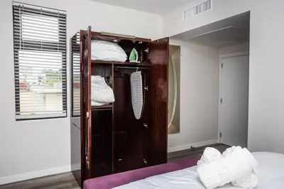 a bedroom with a bed and a wooden closet at One Bedroom Apartment with Luxurious Furnitures in San Diego