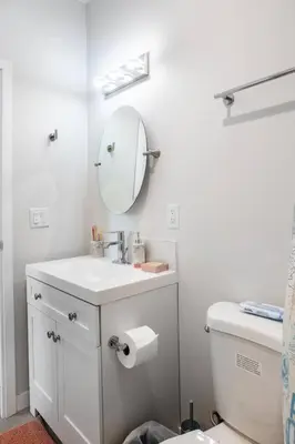 a white bathroom with a sink and a mirror at One Bedroom Apartment with Luxurious Furnitures in San Diego