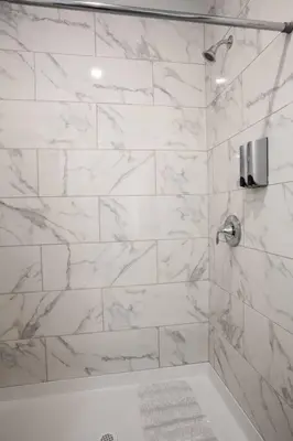a bathroom with a shower with white marble tiles at One Bedroom Apartment with Luxurious Furnitures in San Diego