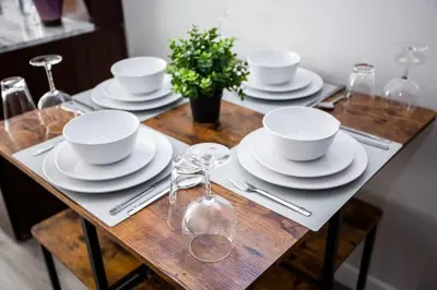 a wooden table with plates and cups and utensils at One Bedroom Apartment with SD Downtown View in San Diego