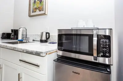a kitchen with a microwave on top of a refrigerator at Cali King Size One Bedroom Luxurious Suite in DTSD in San Diego
