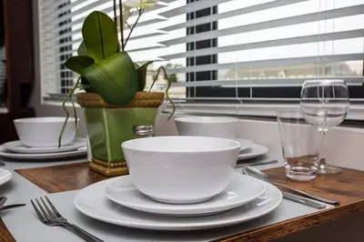 a wooden table with plates and cups and a plant at Prime Location - Awesome View -1 bedroom Apartment in San Diego