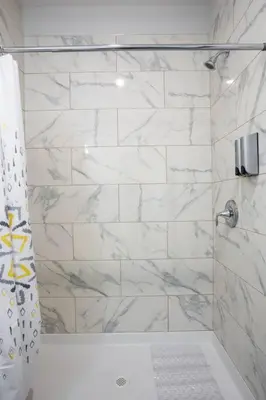 a bathroom with a shower with white marble walls at Prime Location - Awesome View -1 bedroom Apartment in San Diego