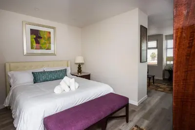 a bedroom with a large white bed with a purple bench at Prime Location - Awesome View -1 bedroom Apartment in San Diego