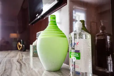 a green vase sitting on a counter next to two bottles at Spacious 1 Bedroom Apartment in Balboa Park in San Diego