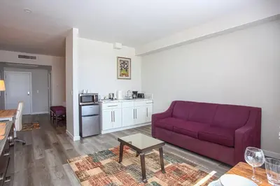 a living room with a red couch and a kitchen at Spacious 1 Bedroom Apartment in Balboa Park in San Diego