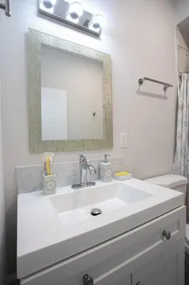 a white bathroom with a sink and a mirror at Spacious 1 Bedroom Apartment in Balboa Park in San Diego