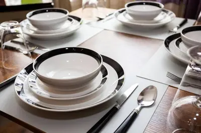 a table with white plates and bowls and spoons at Spacious 1 Bedroom Apartment in Heart of San Diego in San Diego