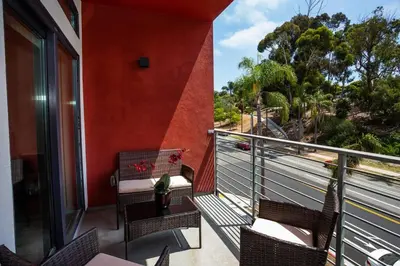 a balcony with chairs and a vase of flowers at Steps to Balboa Park- Brand New Apt - Cozy Studio in San Diego