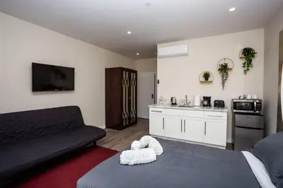 a living room with a couch and a kitchen at Steps to Balboa Park- Brand New Apt - Cozy Studio in San Diego
